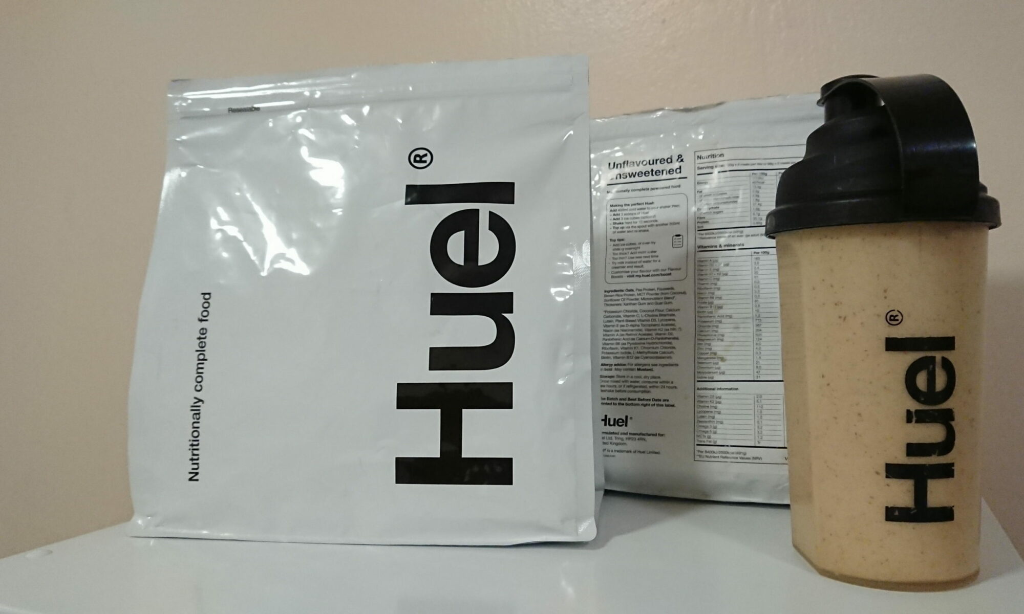 A shaker full of Huel and 2 packets of powder